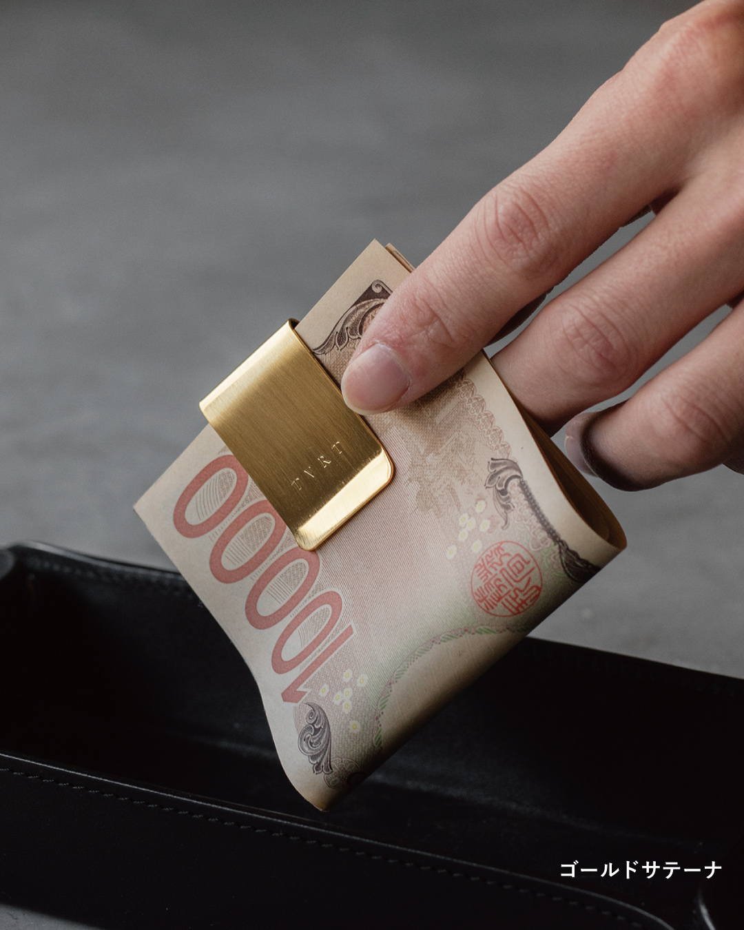 ゴールドサテーナ仕上げの真鍮マネークリップとお札のアップ