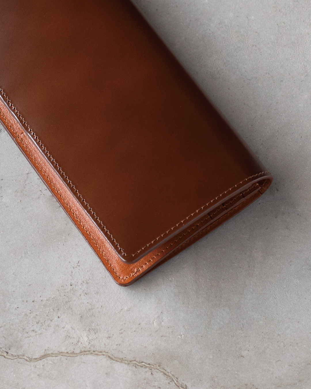 ブラウンのコードバン長財布のアップ画像。美しく整ったステッチと、コードバン特有の綺麗な光沢、内側の牛本革（キップ）の質感が確認できる。