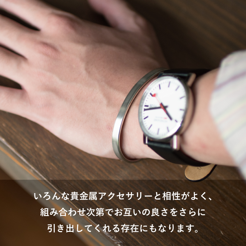 白文字盤の腕時計と重ね付けしたTVRT 真鍮バングルは、貴金属アクセサリーとの相性がよく互いの良さを引き立てます