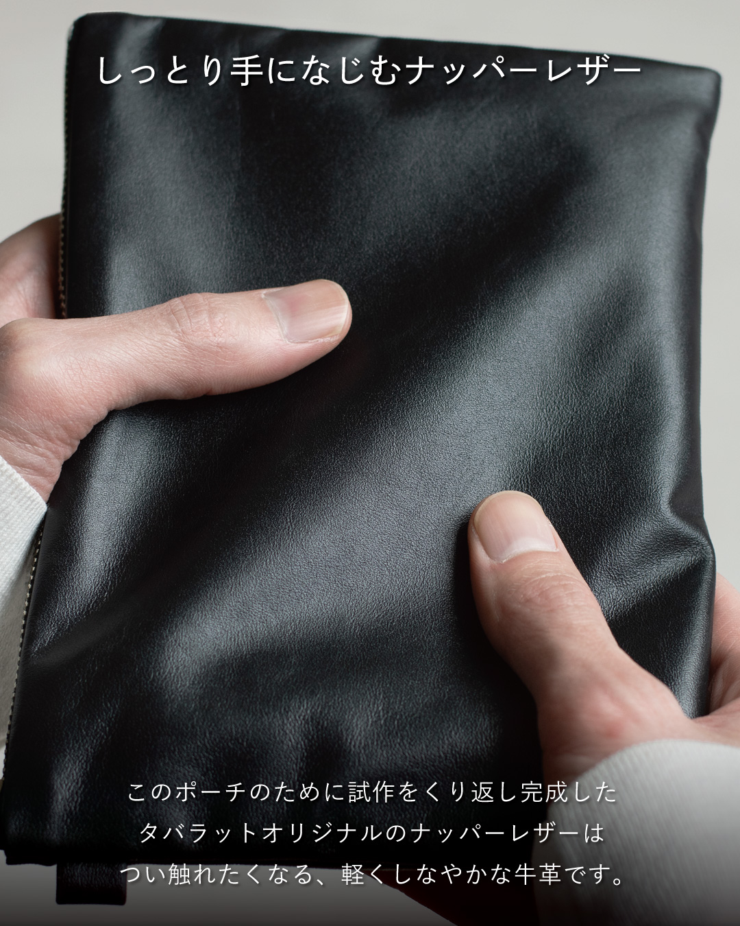 両手で包み込んで持つFOLMAブラックナッパーレザーポーチ。タバラットが試作を重ねて完成させたオリジナル牛革のしっとりしなやかな手触りを訴求するビジュアル。