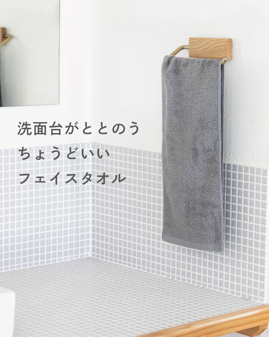 木製の今治タオルハンガーにグレーのちょうどいいフェイスタオルを掛け、洗面台まわりをすっきり見せるインテリア写真。