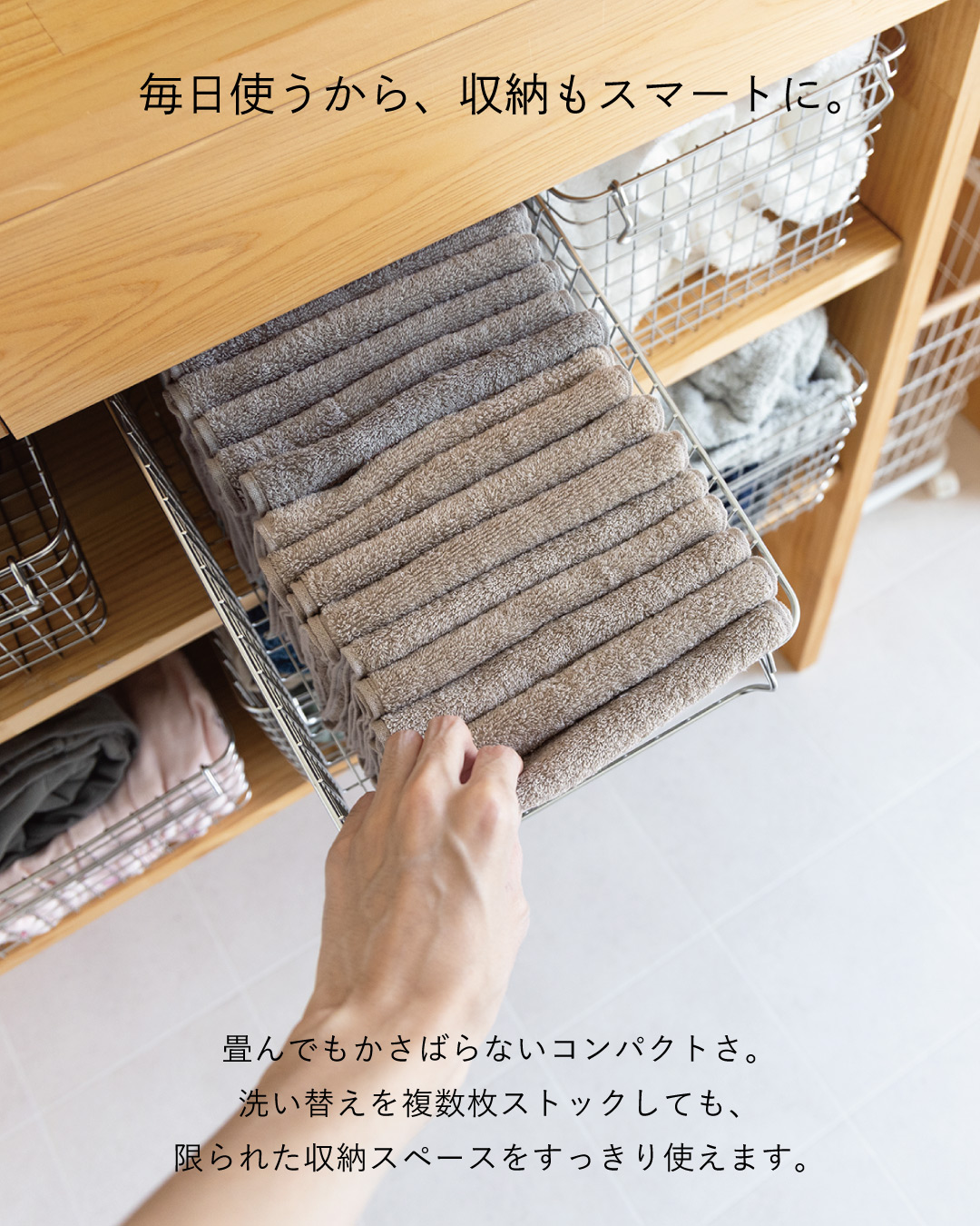 畳んだベージュとグレーのちょうどいいフェイスタオルをワイヤーバスケットに重ねて収納し、コンパクトな洗い替えストックを紹介。