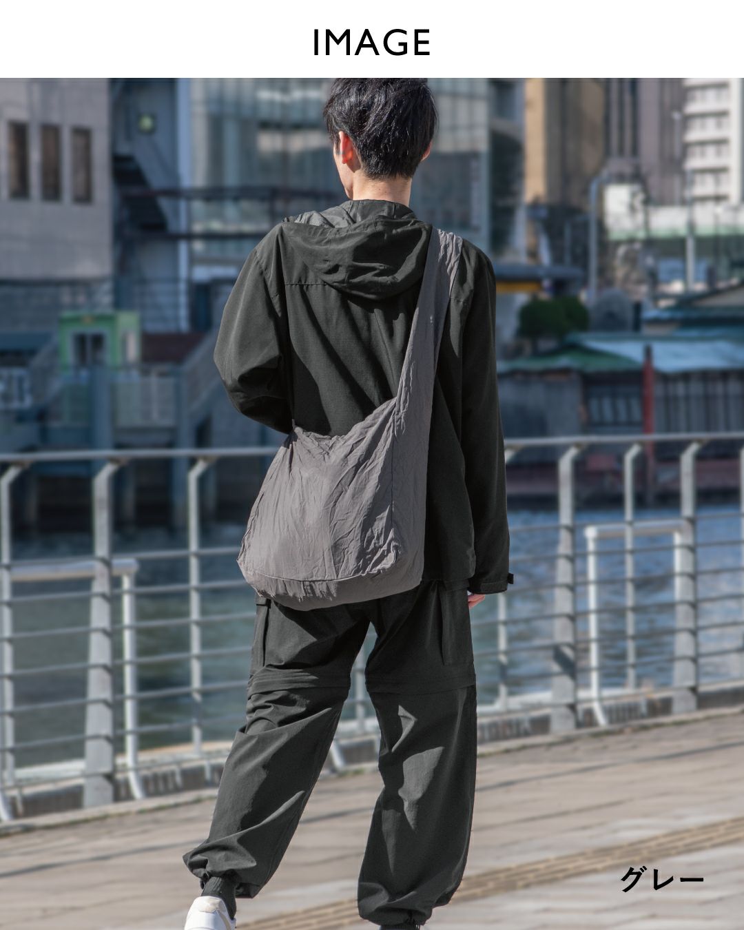 モノトーンコーデの男性とスリングバッグ