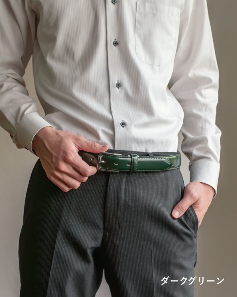 白いシャツとダークグリーンのコードバンベルトを装着したビジネスマンの腰元。シンプルながら高級感のあるスタイルを演出。