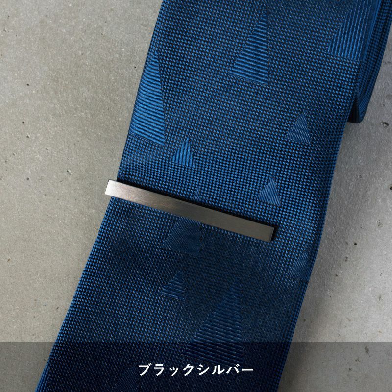 青い柄のネクタイに着用されたブラックシルバーのシンプルなネクタイピン。
