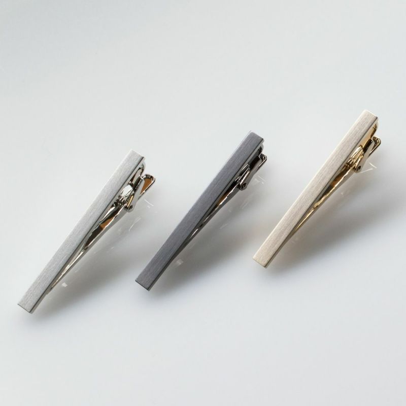 白い背景に斜めに並べられたシルバー、ブラックシルバー、ライトゴールドのシンプルなネクタイピン3本。
