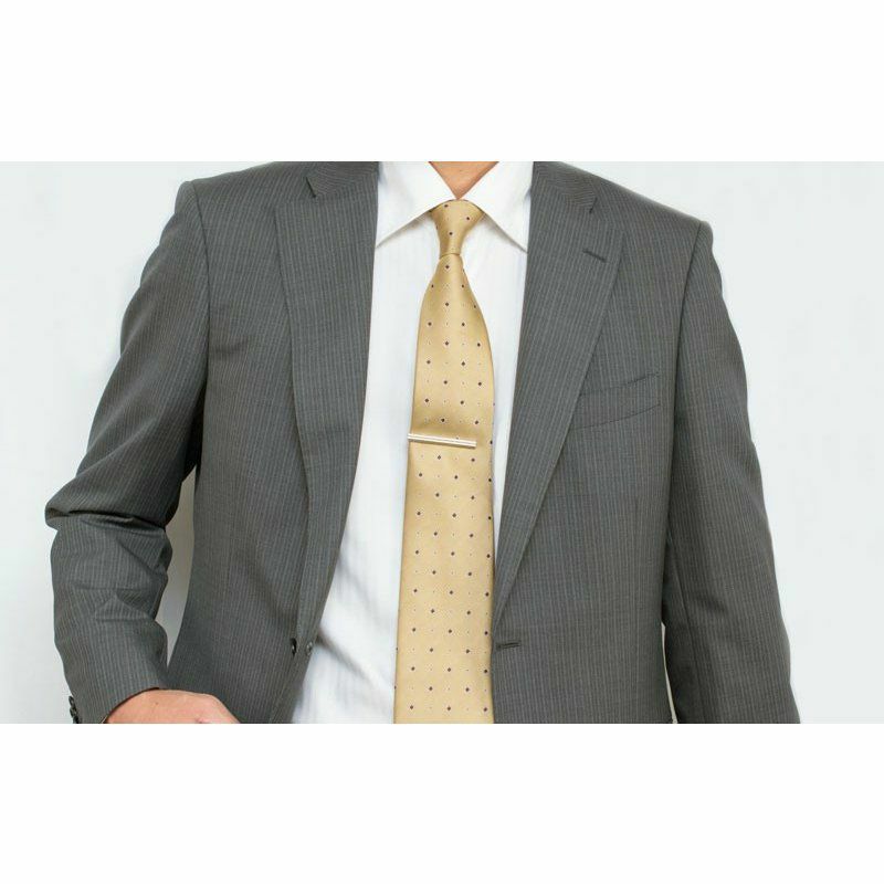 ベージュのドット柄ネクタイに着用されたシルバーのローレットネクタイピン。