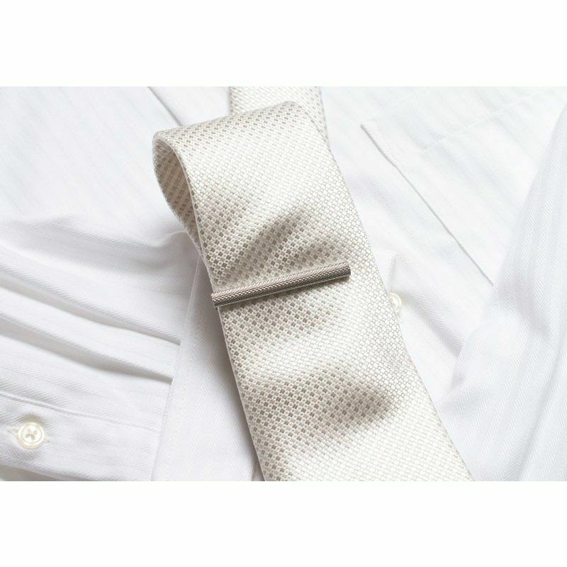 白いネクタイに着用されたシルバーのローレットネクタイピン。