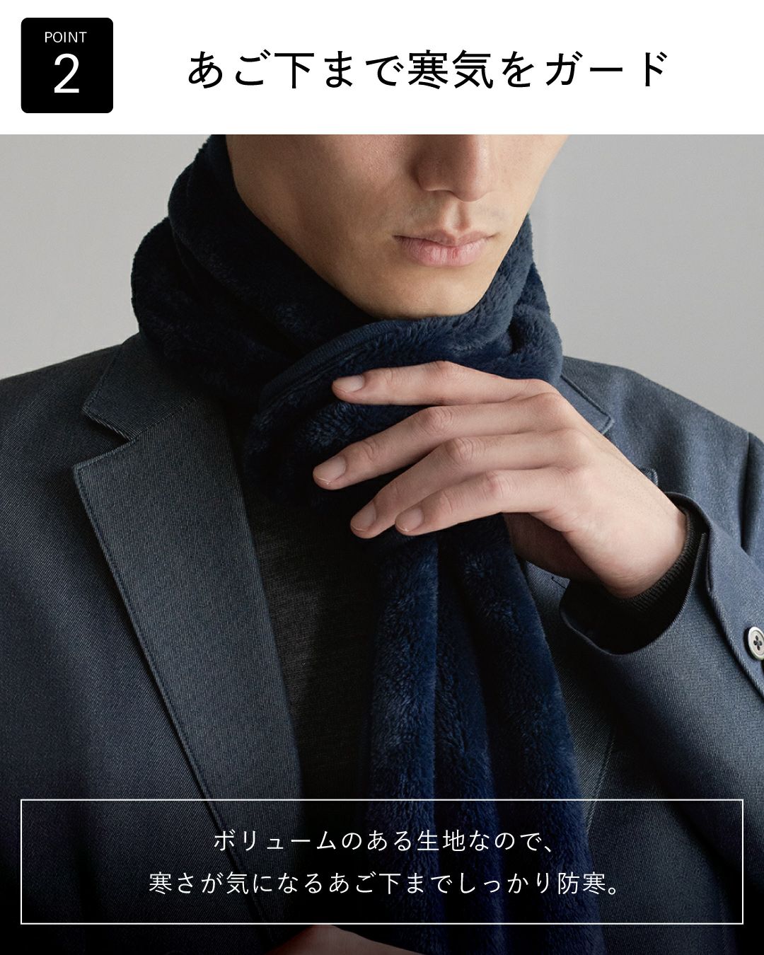 ポイント2：「あご下まで寒気をガード」ネイビー色のフリースマフラー。ボリュームのある生地で首元をしっかり防寒する様子。
