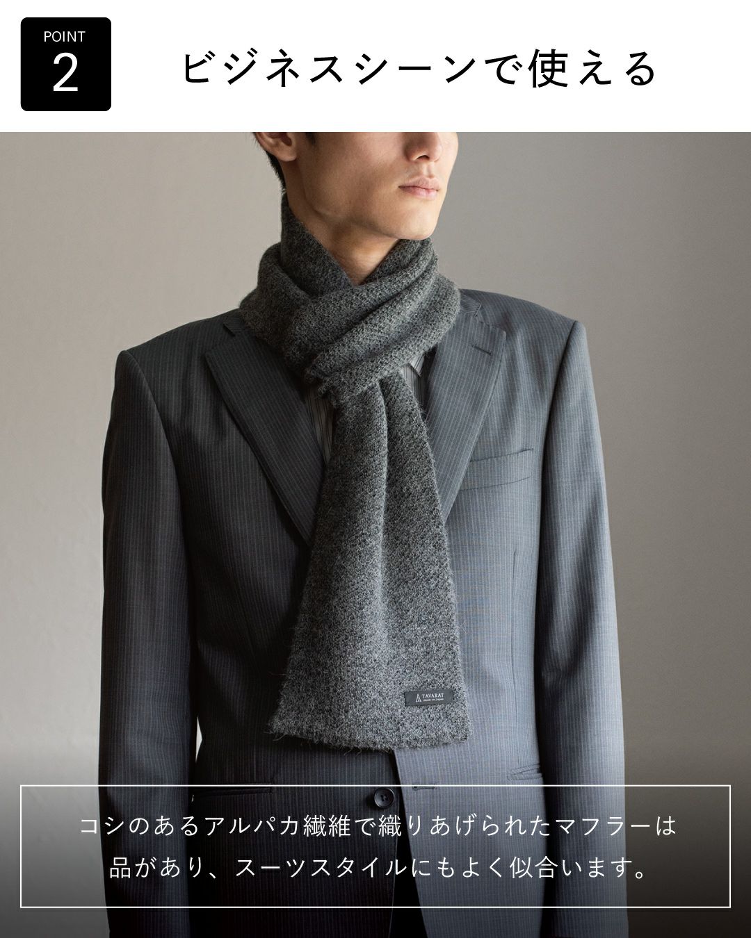 ポイント2：「ビジネスシーンで使える」。コシのあるアルパカ繊維のグレーマフラーが、スーツスタイルにも品よく馴染む様子。