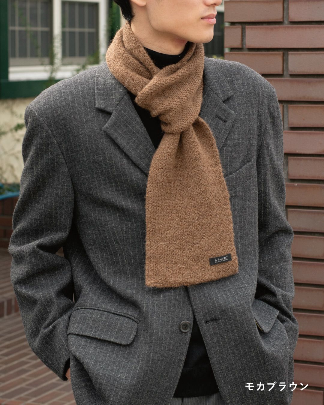 モカブラウン色のアルパカ100%マフラーを巻いた男性の着こなし。柔らかな色味でアクセントになるコンパクトマフラー。