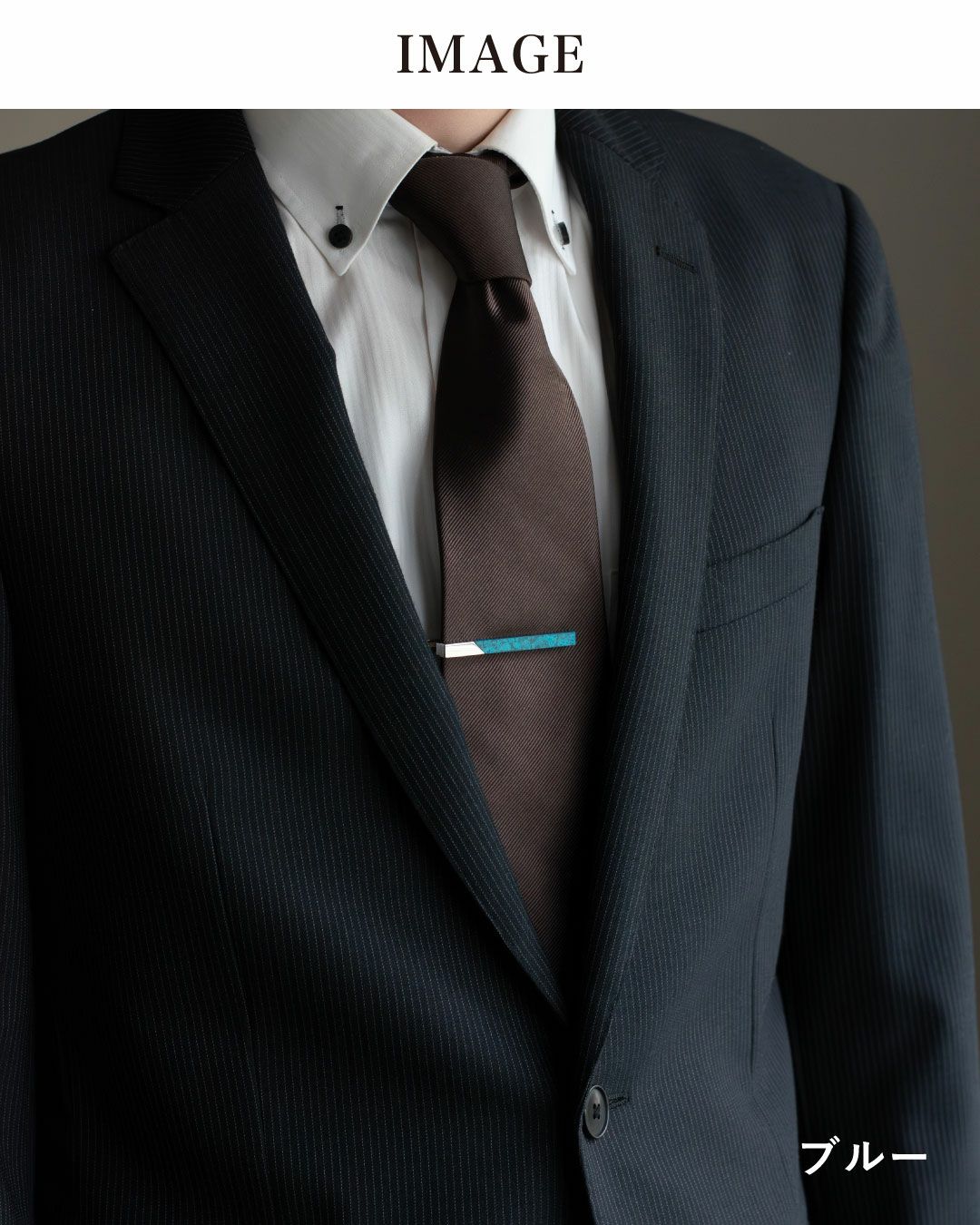 日本製のネクタイピン（ブルー）着用イメージ。ネイビーのスーツに大人の高級感をプラス。
